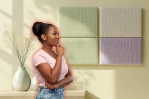 in primo piano una donna di profili che pensa e come sfondo una parete abbellita con dei pannelli nei colori pastello