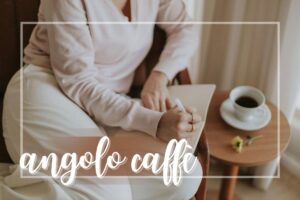 Donna che scrive con accanto tavolino e tazza di caffè