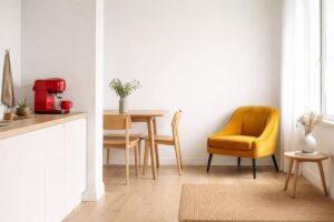 Cucina openspace con caffettiera rossa e poltrona gialla