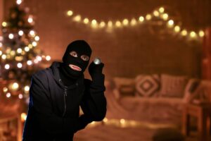 un ladro che si trova all'interno di un soggiorno vuoto addobbato con decorazioni natalizie