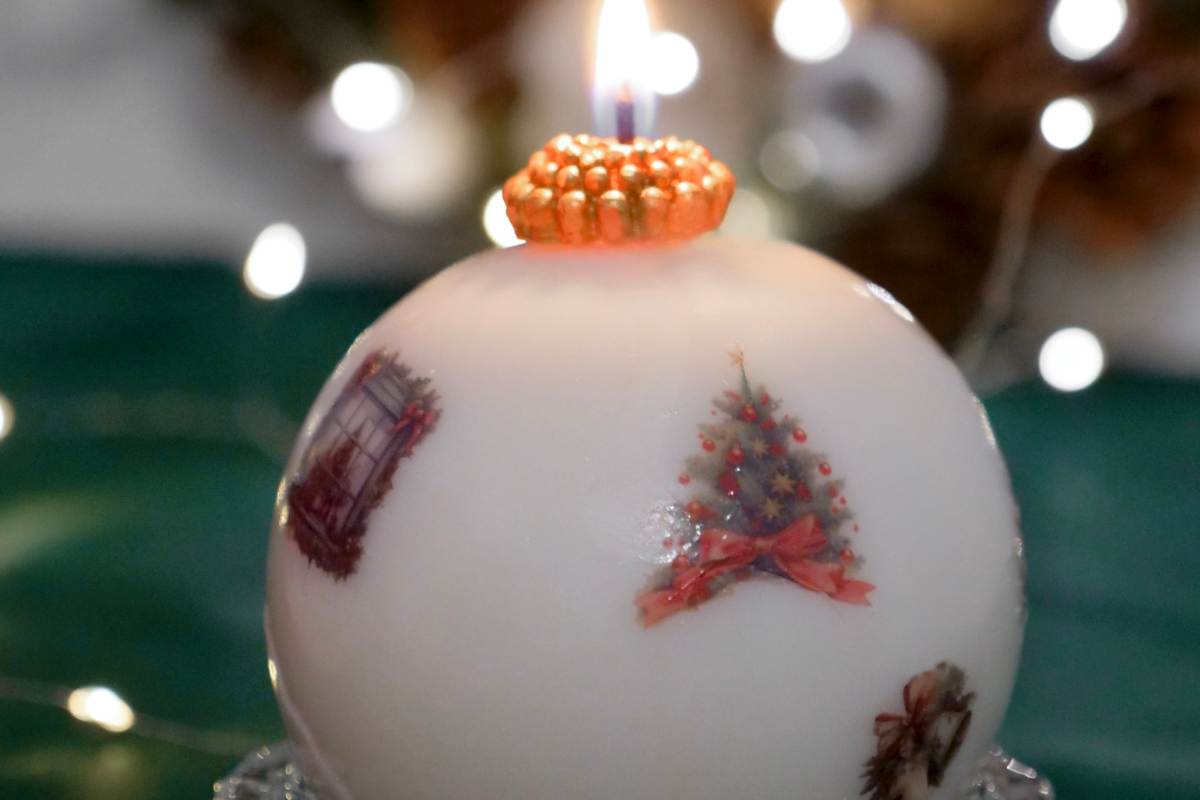 candela rotonda con decorazioni natalizie accesa