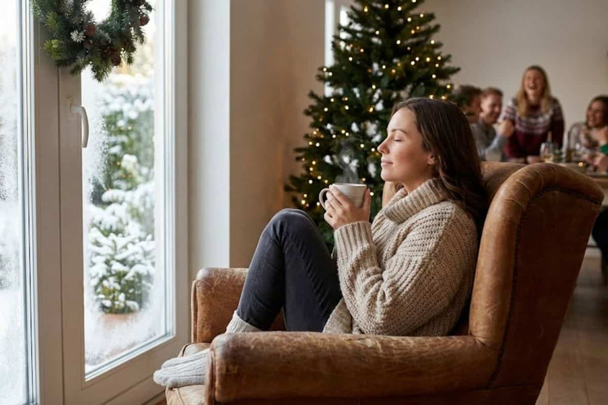 donna seduta in un angolo accogliente accanto a una grande finestra