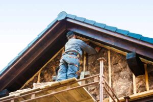 Un operaio che sta installando un cappotto termico alla casa