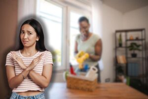 donna sorridente con kit di pulizie e un'altra che fa stop con le mani