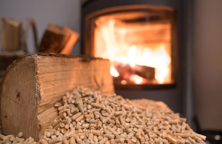 stufa a pellet sullo sfondo e pezzi di pellet in primo piano 