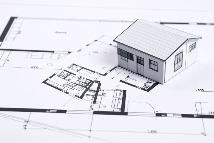 Un progetto di una casa con una miniatura di una casa