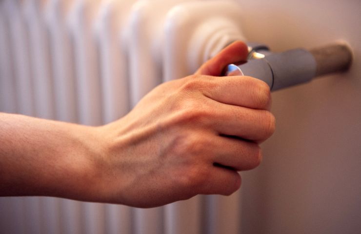 mano che tocca valvola del termosifone