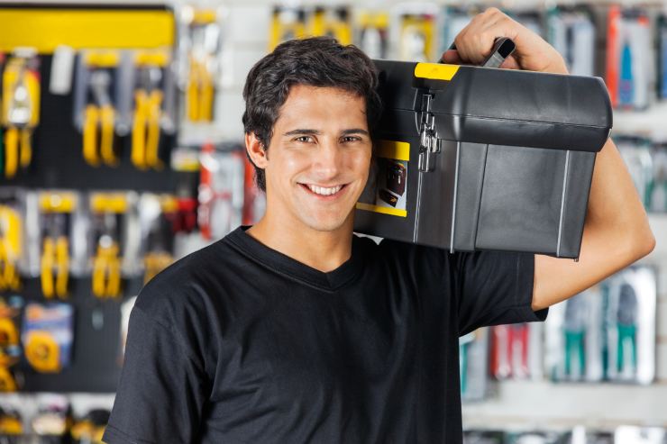 Un uomo che tiene in mano una cassetta degli attrezzi