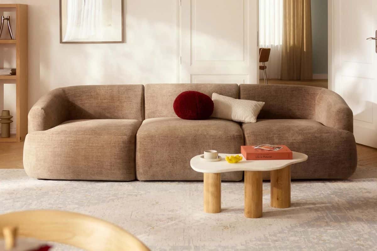 Divano color sabbia con cuscini e tavolino basso