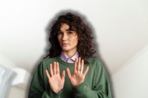 luce cucina sullo sfondo e donna che fa stop con le mani in primo piano