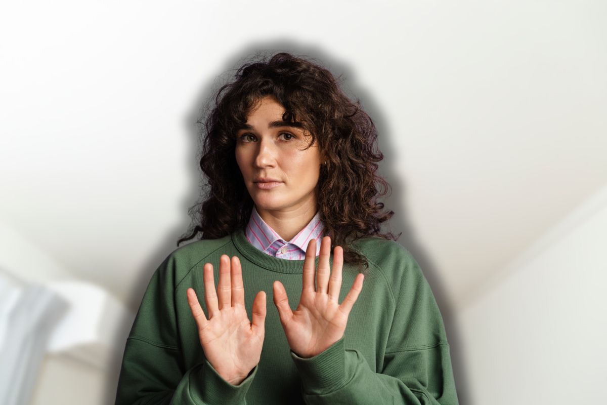 luce cucina sullo sfondo e donna che fa stop con le mani in primo piano