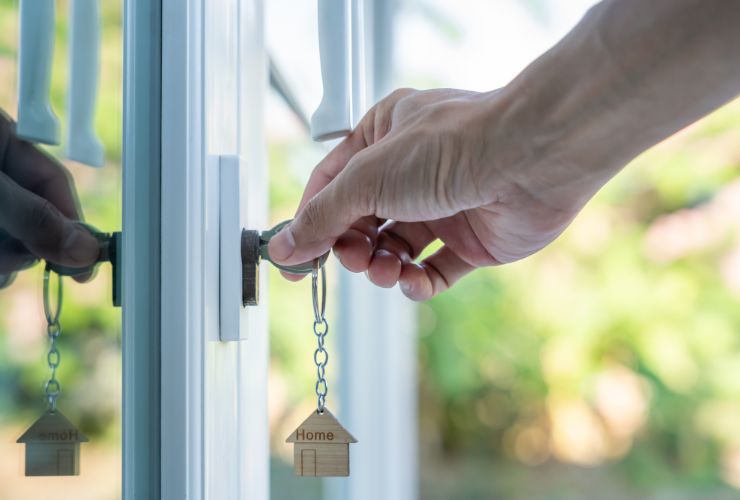 persona che mette chiavi nella toppa di casa 