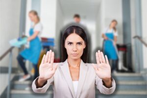 squadra di pulizie che pulisce androne condominio e una donna che fa stop con le mani