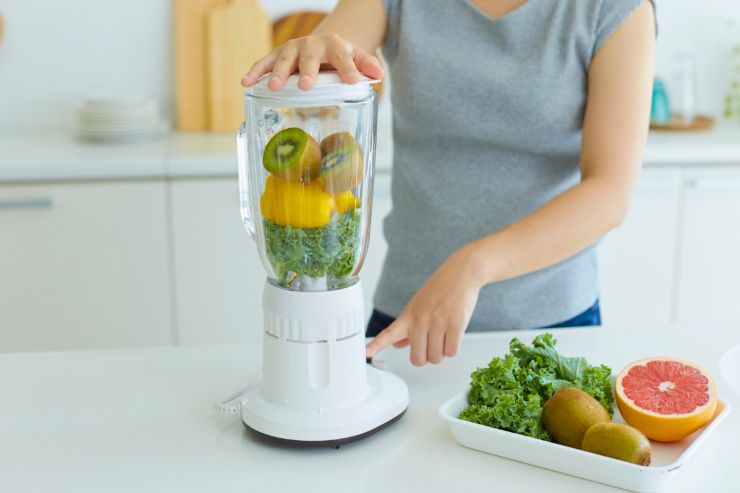 Una persona che attiva un frullatore