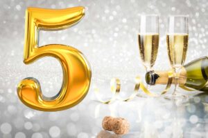 bicchieri con spumante, bottiglia aperta, numero 5 in oro