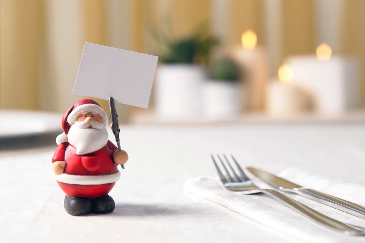 tavola apparecchiata con piccolo segna posto a forma di Babbo Natale
