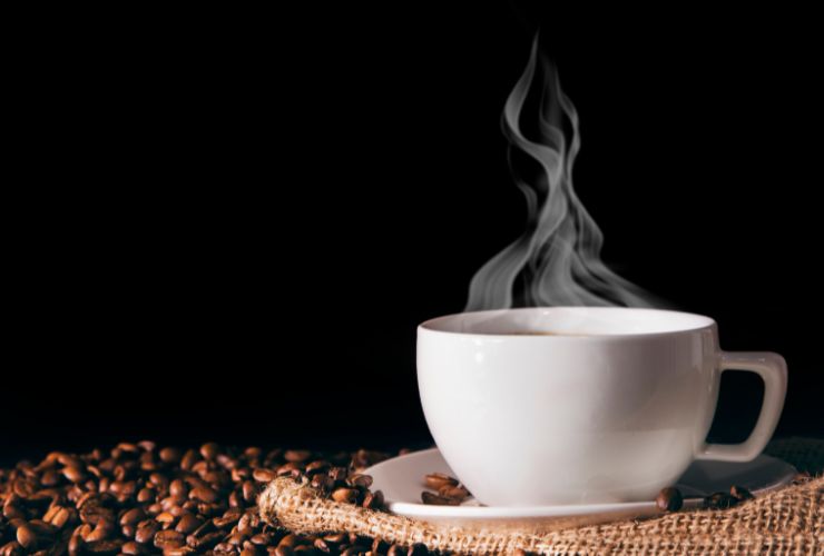 tazzina di caffè con chicchi intorno