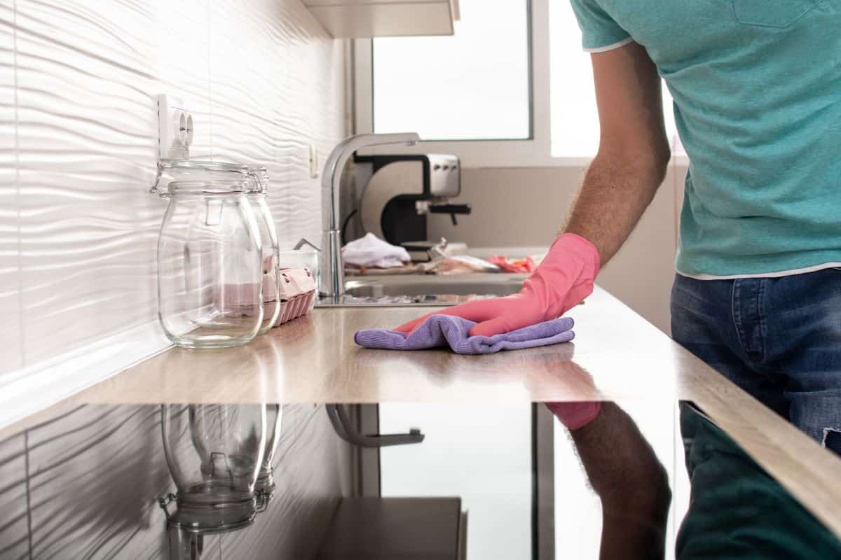 Uomo che pulisce cucina