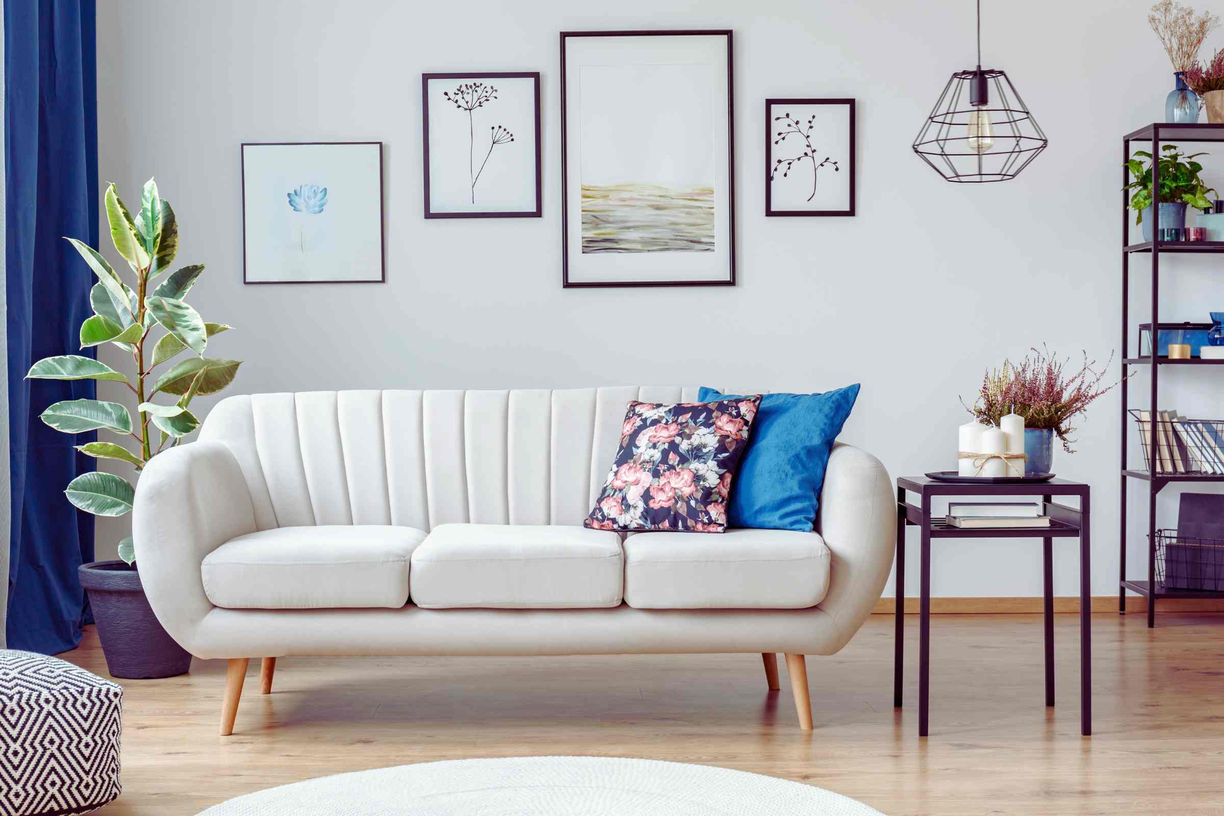 salotto con divano tavolino e quadri appesi sulla parete