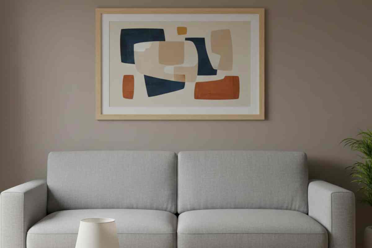 quadro colorato posizionato su una parete di un altro colore sopra ad un divano