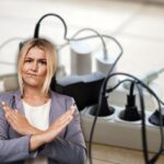 sfondo con una multipresa piena di caricatori inseriti e in primo piano una donna che dice no