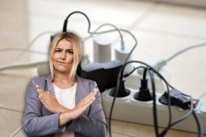 sfondo con una multipresa piena di caricatori inseriti e in primo piano una donna che dice no