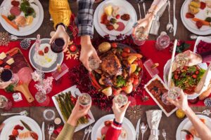 tavola imbandita per natale con mani che fanno un brindisi