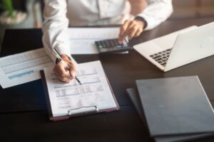persona seduta ad una scrivania che fa conti