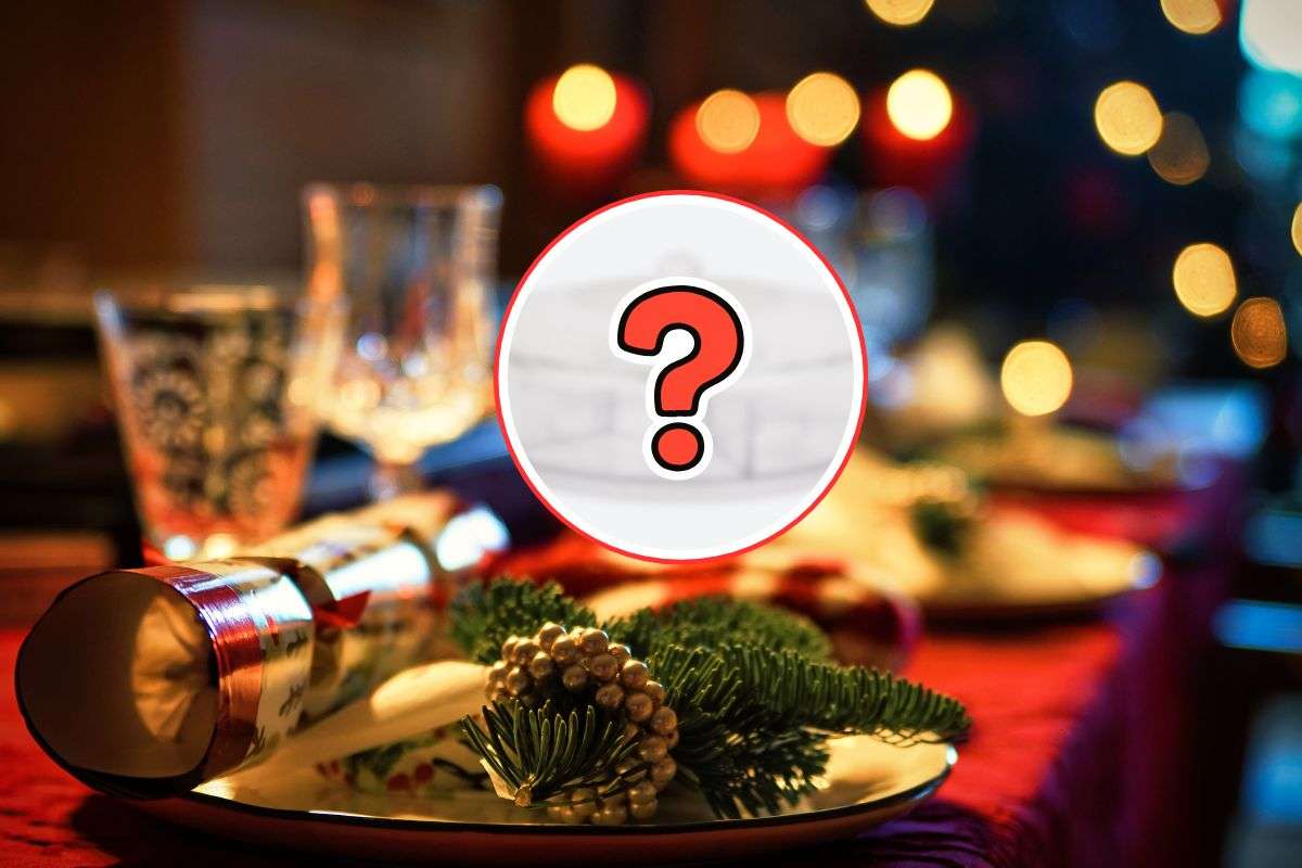 sfondo di una tavola apparecchiata per natale e in primo piano un oggetto misterioso con punto interrogativo