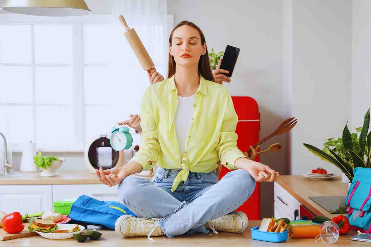 donna seduta sopra il piano di lavoro della cucina contornata di oggetti di accessori