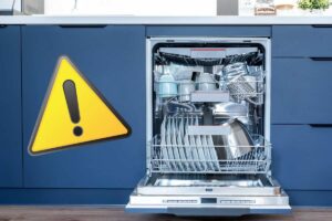 Una lavastoviglie aperta ed un segnale di pericolo sulla sinistra