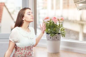 donna che sente un profumo gradevole provenire da una pianta