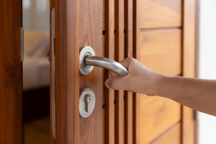 Una mano di una persona che apre una porta