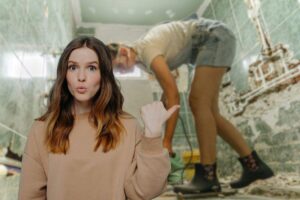 come sfondo una donna che toglie le mattonelle dal bagno in primo piano una donna stupita