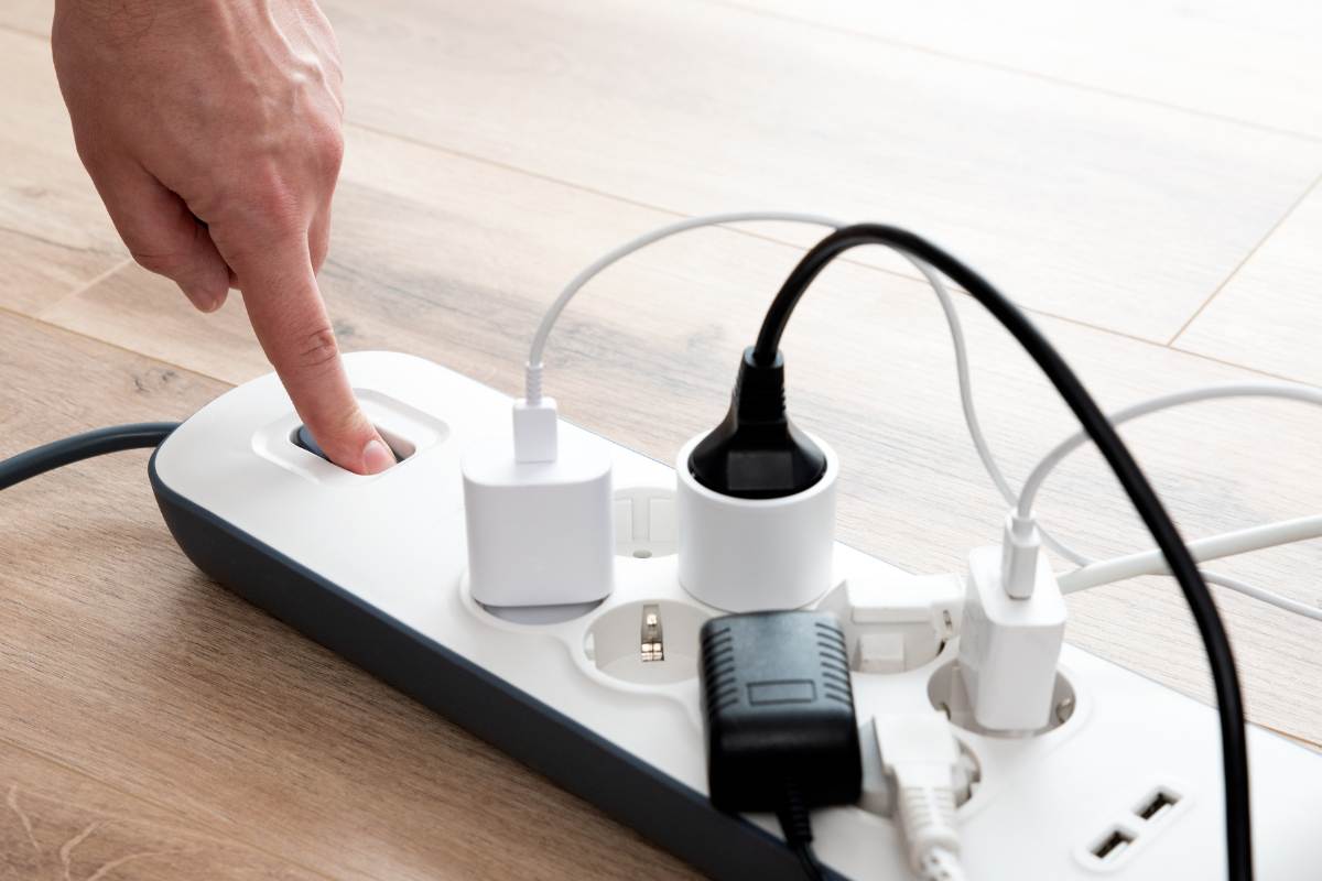 ciabatta con tante prese collegate e mano che spenge