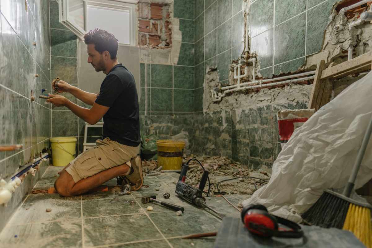 Un uomo che sta lavorando per ristrutturare un bagno