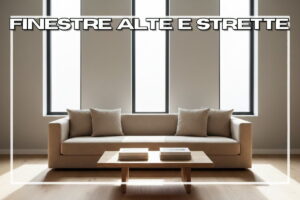 Divano chiaro con tavolino e tre finestre strette alle spalle