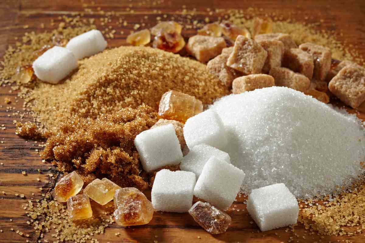 zucchero bianco e grezzo in due mucchietti e zolle