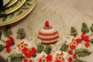 tovaglia decorata con pallina bianca e rossa e fiori rossi con piatti decorati