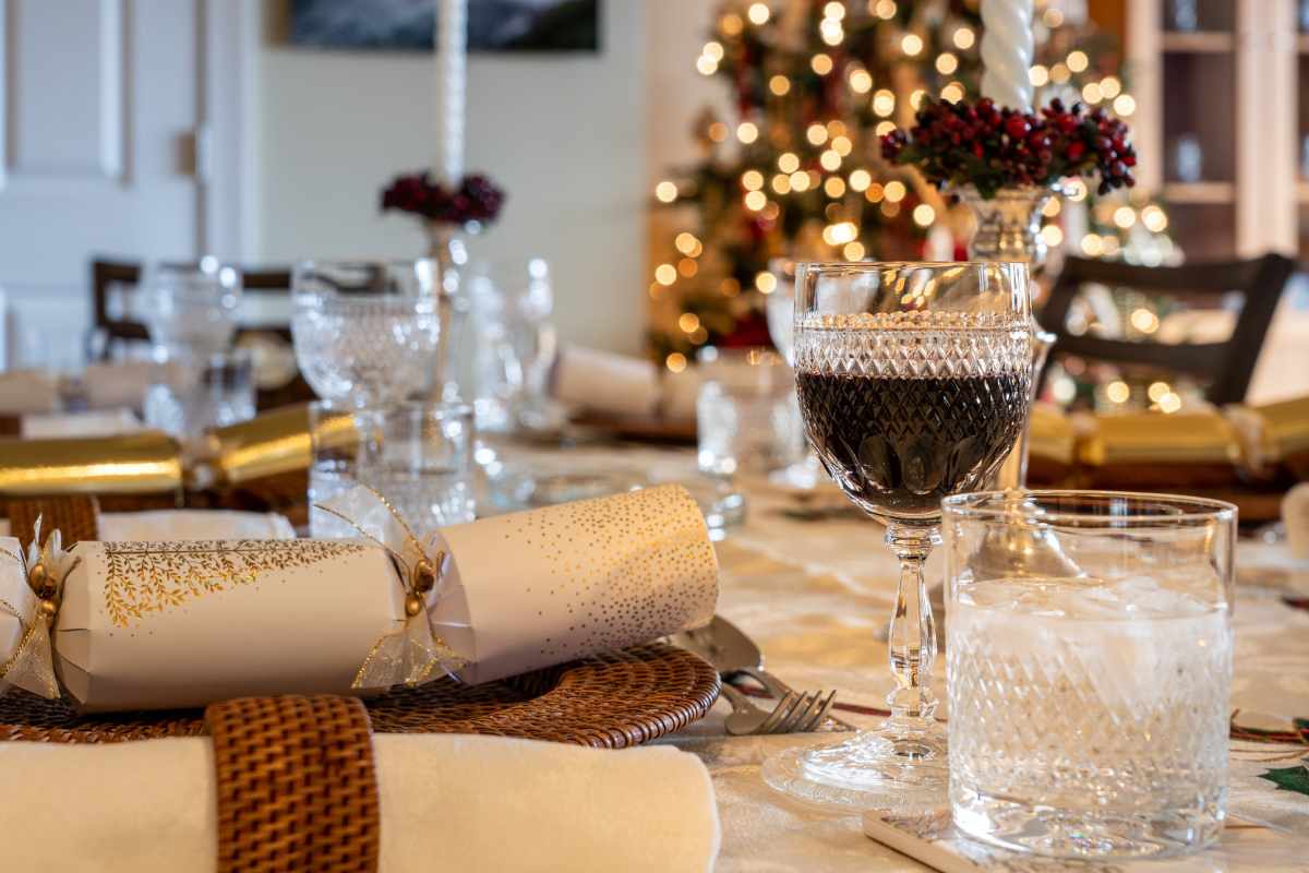 tovagliolo bianco con porta tovagliolo bicchiere con vino e albero sullo sfondo