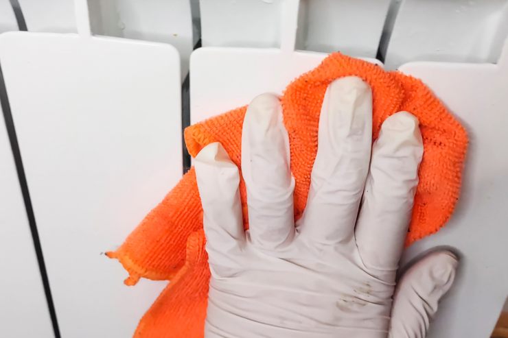 Un uomo che passa una pezza sui termosifoni