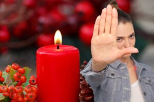 candela rossa accesa bacche e donna che fa segno stop con la mano