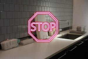 Una cucina fatta di piastrelle ed un insegna di "Stop" in primo piano