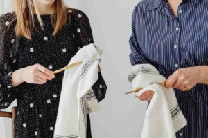 Un uomo ed una donna che usano dei strofinacci per asciugare dei cucchiai in legno