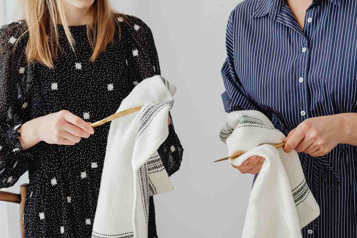 Un uomo ed una donna che usano dei strofinacci per asciugare dei cucchiai in legno