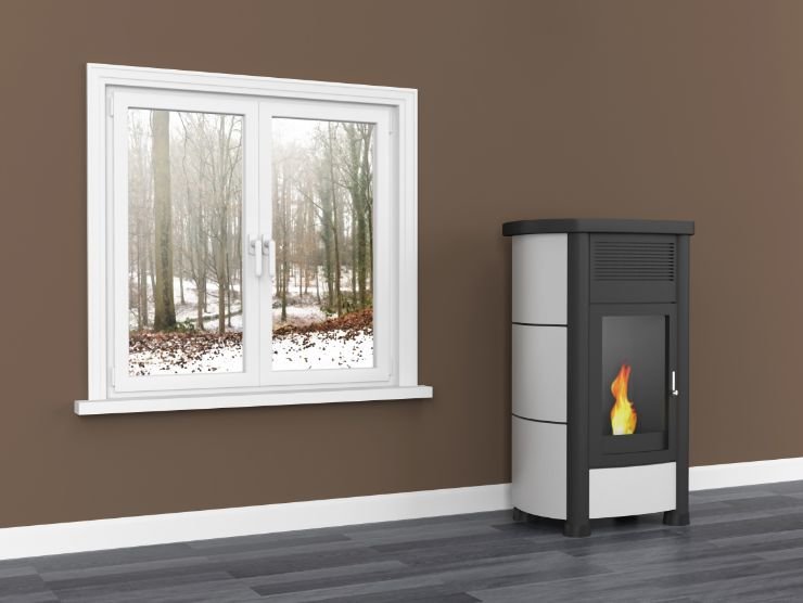 ambiente moderno con una stufa a pellet posta vicino ad una finestra da cui si vede un paesaggio innevato