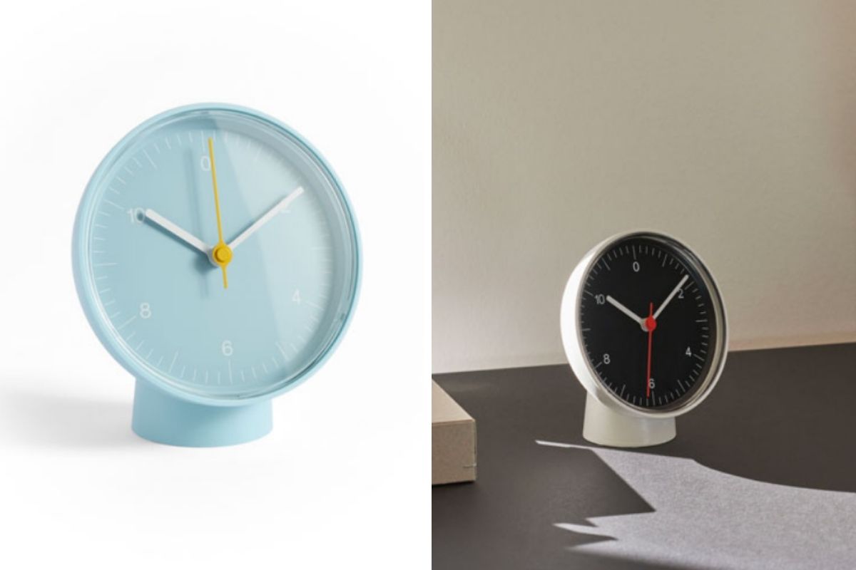 Sveglia analogica azzurra e sveglia bianca sul tavolo scuro