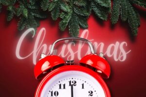 Sveglia rossa in primo piano e albero di Natale in secondo piano