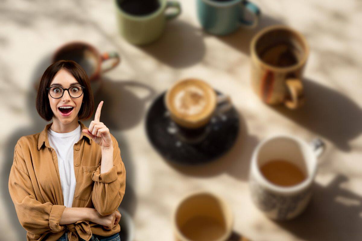 tazzine di caffè spaiate e donna sorridente che ha un'idea