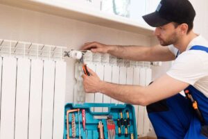 tecnico che ripara termosifoni